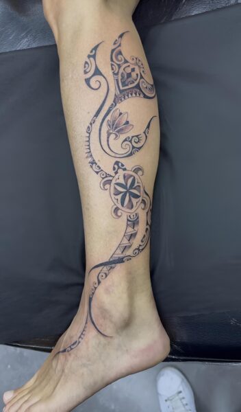 Volutes ornementales fines en noir et gris sur la jambe