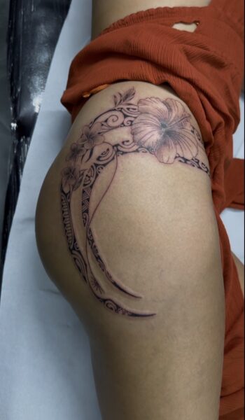 Fleurs et volutes en noir et gris sur la cuisse