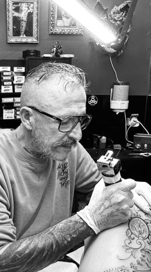 Adrien, tatoueur à Nouméa, en séance de tatouage dans son studio