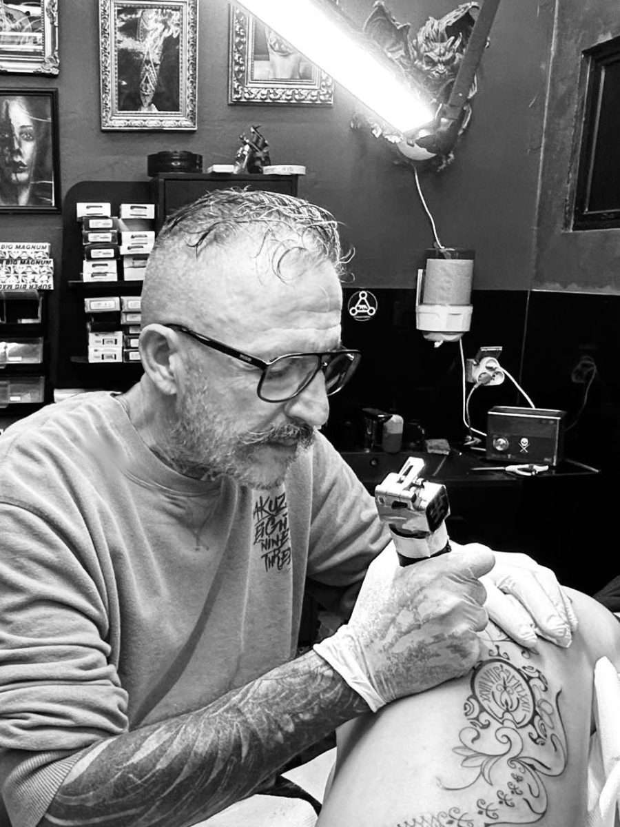Adrien au travail dans son studio de Nouméa Adrien, tatoueur à Nouméa, tatouant un motif ornemental dans son studio