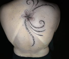 Fleur et volutes en noir et gris sur le haut du dos