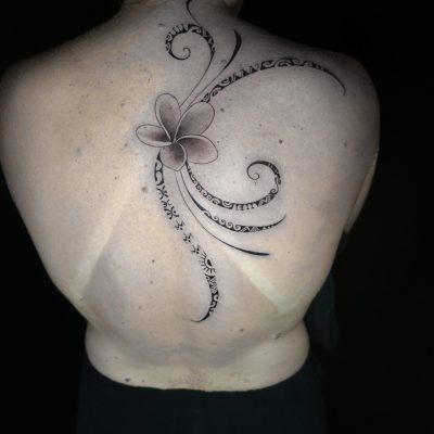 Fleur et volutes en noir et gris sur le haut du dos