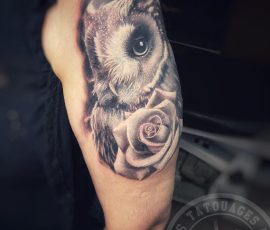 Hibou et rose en noir et gris sur le bras