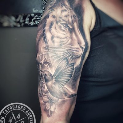 Lion et ornements en noir et gris sur l'épaule