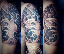 Vagues japonaises en noir et gris sur l'épaule