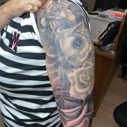Hibou et roses en noir et gris sur le bras