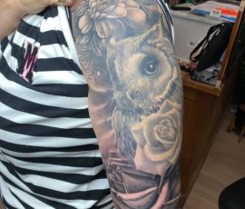 Hibou et roses en noir et gris sur le bras