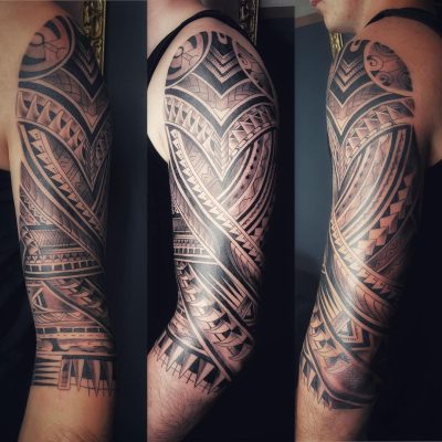 Manche polynésienne dense en noir et gris, motif solaire à l'épaule