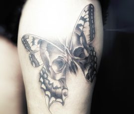 Papillon en noir et gris sur la cuisse