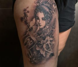 Portrait de femme et fleurs en noir et gris sur la cuisse