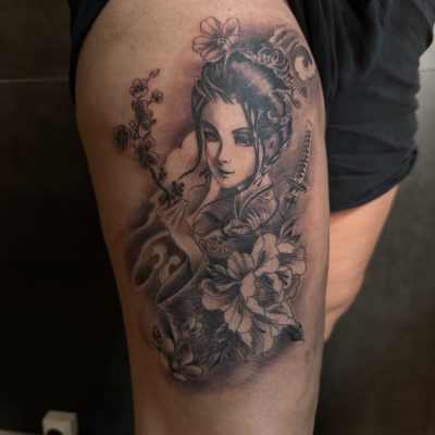 Portrait de femme et fleurs en noir et gris sur la cuisse
