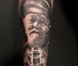 Portrait d'homme et phare en noir et gris sur le bras