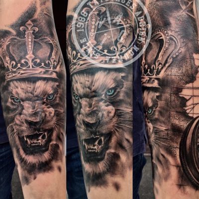 Lion couronné en noir et gris sur l'avant-bras
