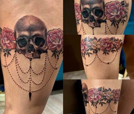 Crâne, roses et guirlandes en couleur sur la cuisse