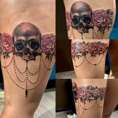 Crâne, roses et guirlandes en couleur sur la cuisse