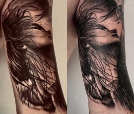 Visage de femme et plumes en noir et gris sur le bras