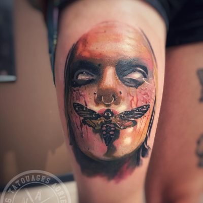 Visage et papillon de nuit en couleur sur la cuisse