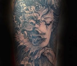 Masque de dragon et portrait de femme en noir et gris sur le bras