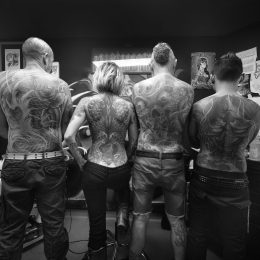 Photographie d'atelier en noir et blanc, dos tatoués