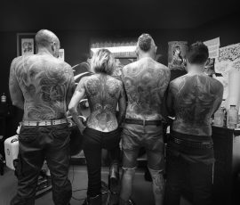 Photographie d'atelier en noir et blanc, dos tatoués