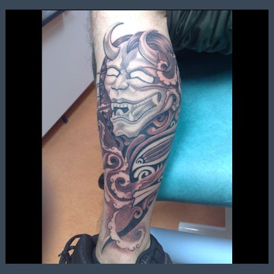 Masque hannya et volutes en noir et gris sur le mollet
