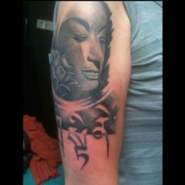 Visage de femme et fleurs en noir et gris sur le bras