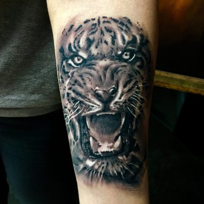 Tête de tigre rugissant en noir et gris sur l'avant-bras