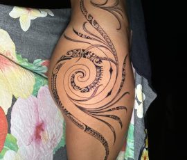 Volutes polynésiennes en noir et gris sur la hanche et la cuisse