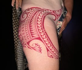 Motif polynésien fraîchement tatoué sur la hanche, vue de profil