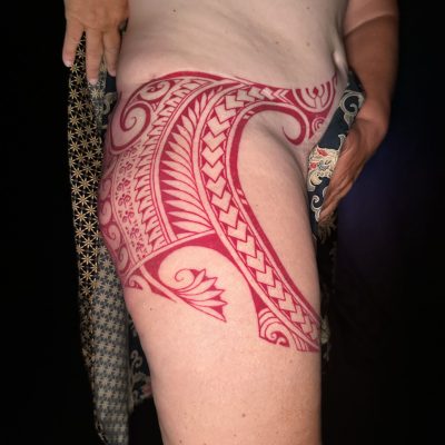 Motif polynésien fraîchement tatoué sur la hanche, vue de profil
