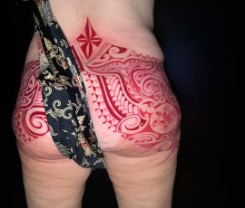 Motif polynésien fraîchement tatoué sur la hanche, vue de dos