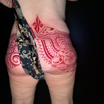 Motif polynésien fraîchement tatoué sur la hanche, vue de dos