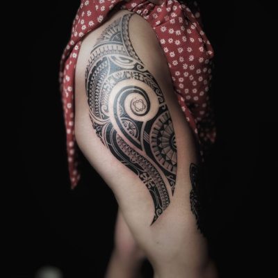Motif polynésien en noir sur la hanche et la cuisse