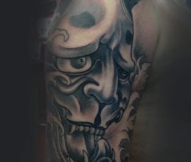 Masque hannya japonais en noir et gris sur l'épaule