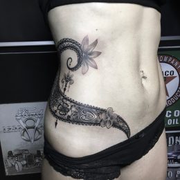 Dentelle et lézard en noir et gris sur la hanche