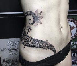 Dentelle et lézard en noir et gris sur la hanche
