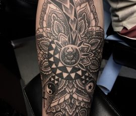 Mandala ornemental en noir et gris sur l'avant-bras