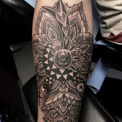 Mandala ornemental en noir et gris sur l'avant-bras
