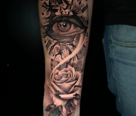 Œil et roses en noir et gris sur l'avant-bras
