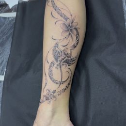 Volutes florales fines en noir et gris sur la jambe