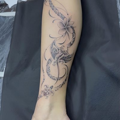 Fleurs et volutes fines en noir et gris sur la jambe