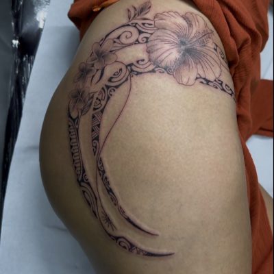 Fleurs et volutes en noir et gris sur la cuisse