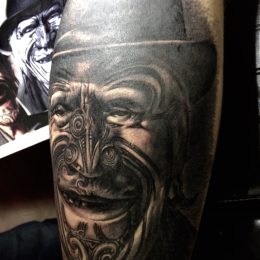 Masque maori en noir et gris, réalisme sur la cuisse