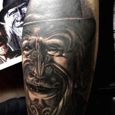 Masque maori en noir et gris, réalisme sur la cuisse