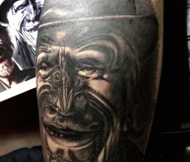 Masque maori en noir et gris, réalisme sur la cuisse
