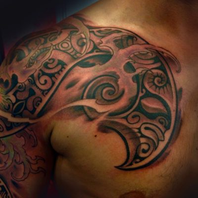 Motif polynésien noir sur le pectoral et l'épaule