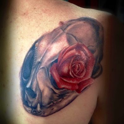 Rose rouge et crâne en couleur sur l'épaule