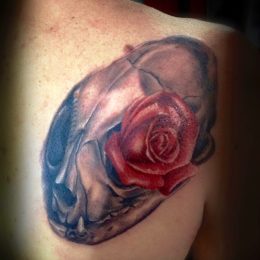 Rose rouge et crâne en couleur sur l'épaule