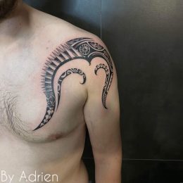 Motif polynésien en noir sur le pectoral et l'épaule