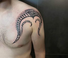Motif polynésien en noir sur le pectoral et l'épaule